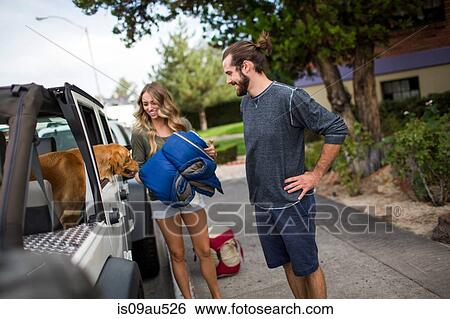 Young couple and dog preparing to load jeep for road trip View Large Photo Image Stock Photograph - Young couple and dog preparing to load jeep for road trip. Fotosearch