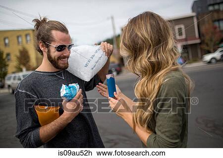 Stock Image - Young couple carrying provisions for road trip. Fotosearch