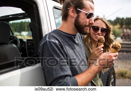 Young couple leaning against jeep eating ice cream cones View Large Photo Image Stock Image - Young couple leaning against jeep eating ice cream cones. Fotosearch