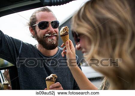 Young couple next to jeep messily eating ice cream cones View Large Photo Image Stock Image - Young couple next to jeep messily eating ice cream cones. Fotosearch