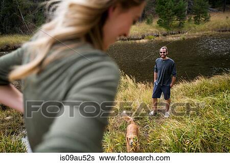 Stock Photograph - Young couple on riverside with dog, Lake Tahoe, Nevada, USA. Fotosearch