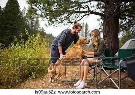 Stock Photo - Young couple petting dog at campsite, Lake Tahoe, Nevada, USA. Fotosearch