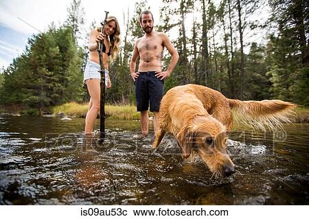 Young couple watching pet dog in river, Lake Tahoe, Nevada, USA View Large Photo Image Stock Image - Young couple watching pet dog in river, Lake Tahoe, Nevada, USA. Fotosearch