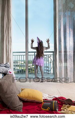 Young girl, wearing party clothes, looking out of window, rear view View Large Photo Image Stock Photo - Young girl, wearing party clothes, looking out of window, rear view. Fotosearch