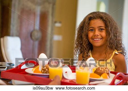 Young girl with breakfast tray looking at camera smiling View Large Photo Image Stock Photo - Young girl with breakfast tray looking at camera smiling. Fotosearch