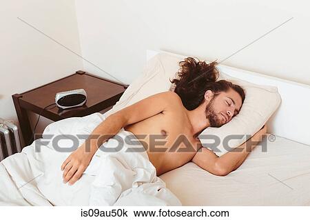 Young man asleep in bed View Large Photo Image Stock Image - Young man asleep in bed. Fotosearch