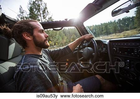 Stock Photo - Young man driving jeep on road trip, Lake Tahoe, Nevada, USA. Fotosearch