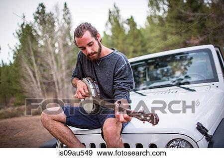Young man playing banjo on jeep hood, Lake Tahoe, Nevada, USA View Large Photo Image Stock Photo - Young man playing banjo on jeep hood, Lake Tahoe, Nevada, USA. Fotosearch