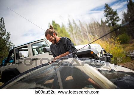 Young man putting up tent in forest, Lake Tahoe, Nevada, USA View Large Photo Image Stock Photograph - Young man putting up tent in forest, Lake Tahoe, Nevada, USA. Fotosearch
