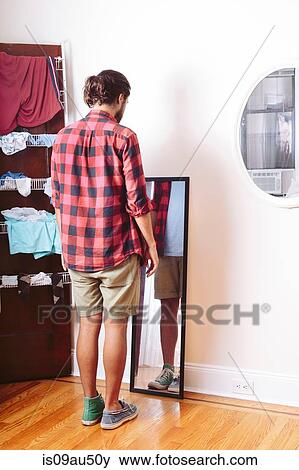 Young man wearing two different shoes, looking in mirror View Large Photo Image Stock Photo - Young man wearing two different shoes, looking in mirror. Fotosearch