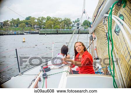 Young woman adjusting sail on sailboat, looking up View Large Photo Image Stock Photo - Young woman adjusting sail on sailboat, looking up. Fotosearch