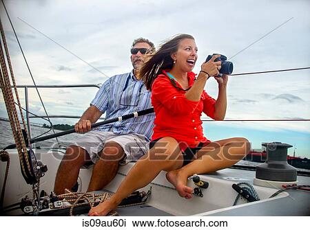 Young woman sitting on sailboat taking photograph smiling View Large Photo Image Stock Image - Young woman sitting on sailboat taking photograph smiling. Fotosearch