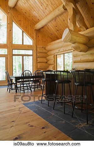 Bar stools at breakfast bar on tiled floor in Eastern white pine log cabin with vaulted ceiling View Large Photo Image Picture - Bar stools at breakfast bar on tiled floor in Eastern white pine log cabin with vaulted ceiling. Fotosearch
