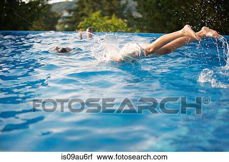 Boys diving into outdoor swimming pool View Large Photo Image Stock Image - Boys diving into outdoor swimming pool. Fotosearch