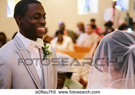 Bridegroom in church wedding ceremony smiling at bride View Large Photo Image Stock Photography - Bridegroom in church wedding ceremony smiling at bride. Fotosearch