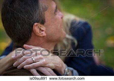 Stock Image - Close up of romantic mature couple in garden. Fotosearch
