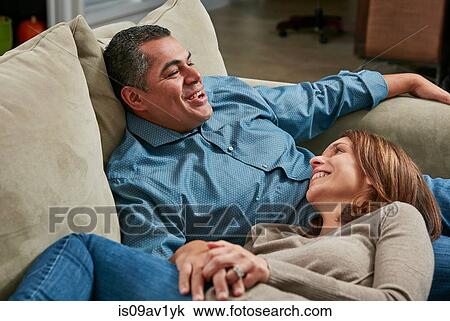 Couple snuggling on sofa, head in lap face to face smiling View Large Photo Image Stock Image - Couple snuggling on sofa, head in lap face to face smiling. Fotosearch