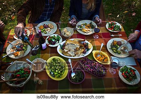 Cropped shot of two mature couples eating roast dinner at garden party View Large Photo Image Stock Photo - Cropped shot of two mature couples eating roast dinner at garden party. Fotosearch