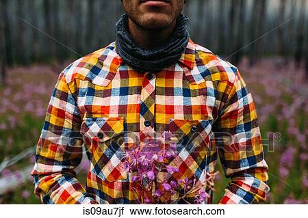 Cropped view of mid adult man wearing checked shirt holding wildflowers, Moraine lake, Banff National Park, Alberta Canada View Large Photo Image Stock Image - Cropped view of mid adult man wearing checked shirt holding wildflowers, Moraine lake, Banff National Park, Alberta Canada. Fotosearch