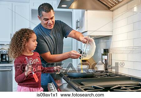 Father helping daughter cook omelette on hob in kitchen, pouring egg into frying pan View Large Photo Image Stock Image - Father helping daughter cook omelette on hob in kitchen, pouring egg into frying pan. Fotosearch