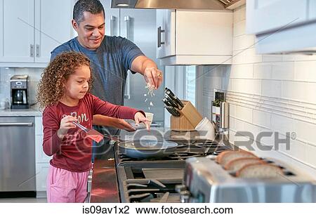 Father helping daughter cook on hob in kitchen, sprinkling cheese View Large Photo Image Stock Image - Father helping daughter cook on hob in kitchen, sprinkling cheese. Fotosearch