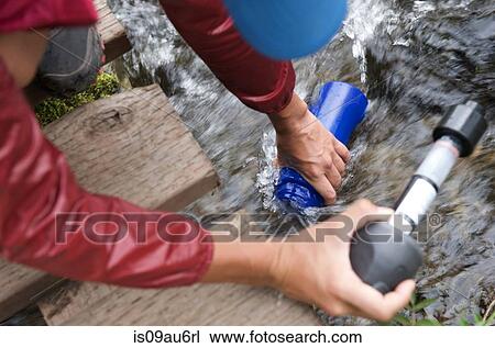 Female hiker with water filter filling water bottle in stream View Large Photo Image Stock Image - Female hiker with water filter filling water bottle in stream. Fotosearch