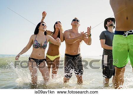 Five adult friends playing American football in sea at Newport Beach, California, USA View Large Photo Image Picture - Five adult friends playing American football in sea at Newport Beach, California, USA. Fotosearch