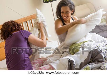 Friends on bed pillow fighting smiling View Large Photo Image Stock Photograph - Friends on bed pillow fighting smiling. Fotosearch
