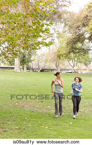 Stock Photo - Full length front view of women wearing sport clothing running on grass. Fotosearch