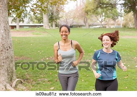 Full length front view of women wearing sport clothing running on grass smiling View Large Photo Image Stock Photo - Full length front view of women wearing sport clothing running on grass smiling. Fotosearch