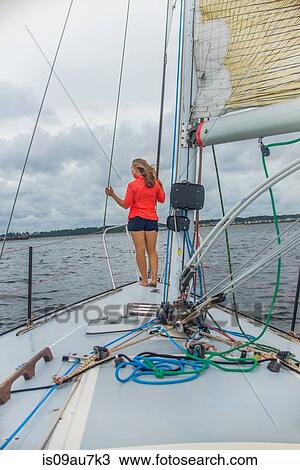 Full length rear view of young woman on bow of sailboat looking away View Large Photo Image Stock Image - Full length rear view of young woman on bow of sailboat looking away. Fotosearch