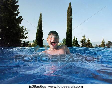 Stock Photograph - Fun portrait of teenage boy in outdoor swimming pool. Fotosearch