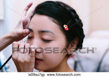 Hands of make up artist applying make up on young woman with eyes closed View Large Photo Image Stock Photo - Hands of make up artist applying make up on young woman with eyes closed. Fotosearch
