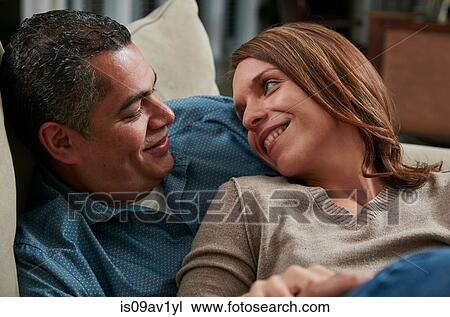 Head and shoulders of couple snuggling on sofa face to face smiling View Large Photo Image Stock Image - Head and shoulders of couple snuggling on sofa face to face smiling. Fotosearch