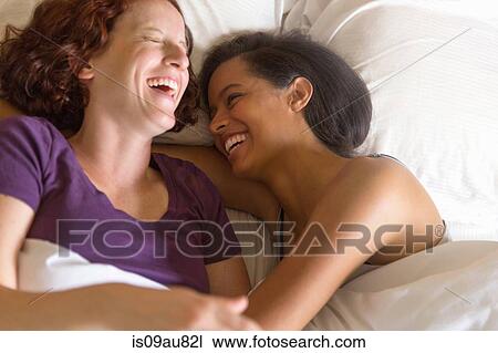 High angle view of lesbian couple lying in bed hugging, laughing View Large Photo Image Stock Image - High angle view of lesbian couple lying in bed hugging, laughing. Fotosearch