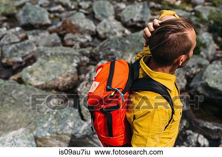 High angle view of mid adult man carrying orange colour backpack, Moraine lake, Banff National Park, Alberta Canada View Large Photo Image Stock Photograph - High angle view of mid adult man carrying orange colour backpack, Moraine lake, Banff National Park, Alberta Canada. Fotosearch