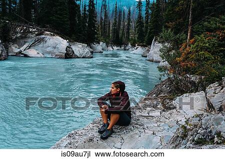 High angle view of mid adult woman sitting by waters edge looking away, Moraine lake, Banff National Park, Alberta Canada View Large Photo Image Stock Image - High angle view of mid adult woman sitting by waters edge looking away, Moraine lake, Banff National Park, Alberta Canada. Fotosearch