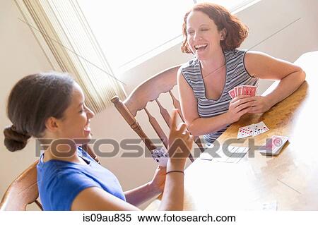 High angled view of young women sitting at dining table playing cards smiling View Large Photo Image Stock Photography - High angled view of young women sitting at dining table playing cards smiling. Fotosearch
