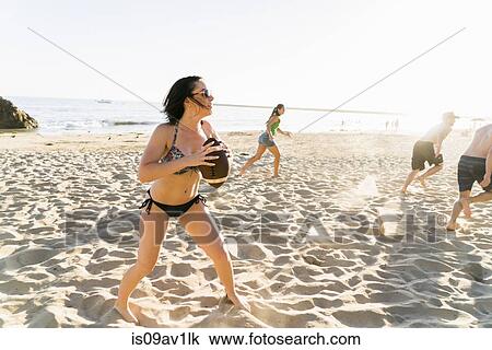 Male and female adult friends playing American football on Newport Beach, California, USA View Large Photo Image Stock Image - Male and female adult friends playing American football on Newport Beach, California, USA. Fotosearch