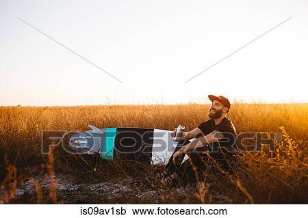 Male surfer drinking beer in field of long grass at sunset, San Luis Obispo, California, USA View Large Photo Image Stock Image - Male surfer drinking beer in field of long grass at sunset, San Luis Obispo, California, USA. Fotosearch