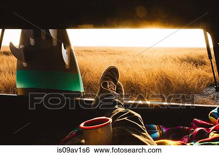 Male surfer with feet up in back of jeep at sunset, San Luis Obispo, California, USA View Large Photo Image Stock Photograph - Male surfer with feet up in back of jeep at sunset, San Luis Obispo, California, USA. Fotosearch