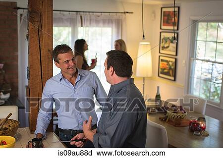 Mature men chatting and preparing food at dinner party View Large Photo Image Stock Image - Mature men chatting and preparing food at dinner party. Fotosearch