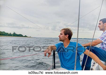 Men relaxing on sailboat looking away at view View Large Photo Image Stock Image - Men relaxing on sailboat looking away at view. Fotosearch