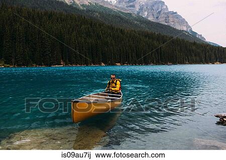 Mid adult man paddling canoe on Moraine lake, looking at camera, Banff National Park, Alberta Canada View Large Photo Image Stock Image - Mid adult man paddling canoe on Moraine lake, looking at camera, Banff National Park, Alberta Canada. Fotosearch