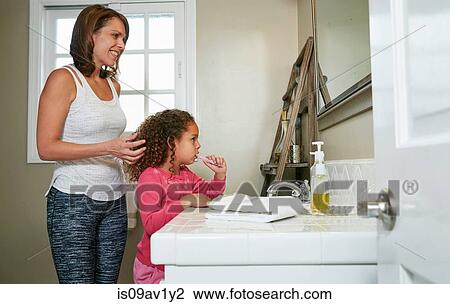 Mother and daughter in bathroom at sink brushing teeth View Large Photo Image Stock Image - Mother and daughter in bathroom at sink brushing teeth. Fotosearch
