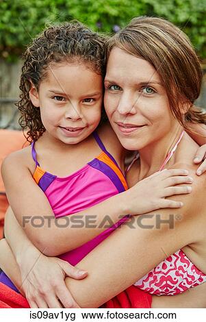 Mother and daughter wearing swimwear hugging, looking at camera smiling View Large Photo Image Stock Image - Mother and daughter wearing swimwear hugging, looking at camera smiling. Fotosearch