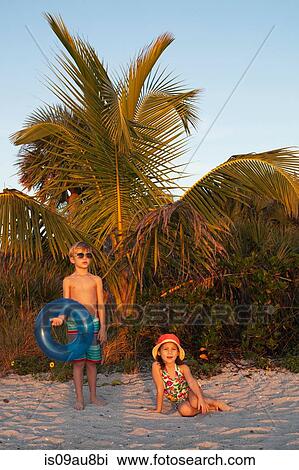 Portrait of girl and brother looking out from beach, Sanibel, Florida, USA View Large Photo Image Stock Image - Portrait of girl and brother looking out from beach, Sanibel, Florida, USA. Fotosearch