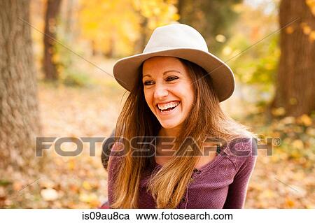 Stock Image - Portrait of happy of young woman in autumn forest. Fotosearch