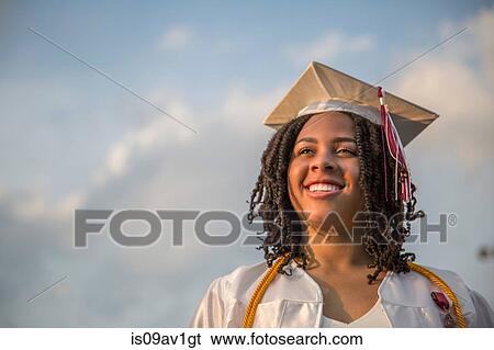 Stock Photograph - Portrait of happy teenage girl at graduation ceremony. Fotosearch