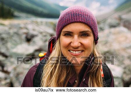 Portrait of mid adult woman wearing knit hat looking at camera smiling, Moraine lake, Banff National Park, Alberta Canada View Large Photo Image Stock Photo - Portrait of mid adult woman wearing knit hat looking at camera smiling, Moraine lake, Banff National Park, Alberta Canada. Fotosearch